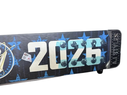 A custom snowboard featuring the year '2026' in large white and light blue letters, decorated with light bulbs, and blue star patterns on a black background. The brand 'AI STIVES' is visible on the tail.