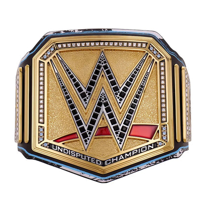 WWE Undisputed Champion belt featuring a gold-toned central plate with a large black and silver WWE logo, bordered by small clear stones, with red and black lower detailing and the words 'UNDISPUTED CHAMPION' on a white background.