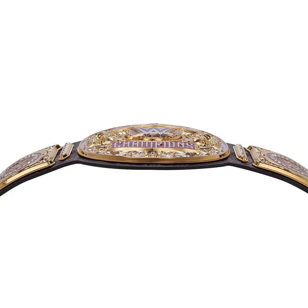 A close-up of a championship belt featuring a gold-toned central plate with 'CHAMPIONS' in purple lettering, flanked by ornate side plates and a black strap, shown against a plain white background.