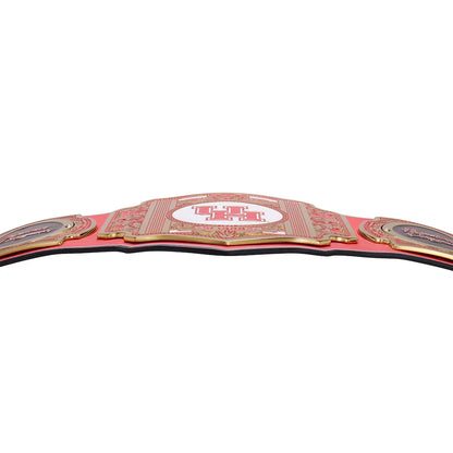 A red and gold championship belt with ornate metal plates, shown against a plain white background.