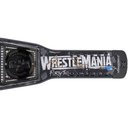 A signed WrestleMania Forty-Two championship belt from WWE, featuring a black and gray textured design with gold signatures and white lettering, set against a plain white background.