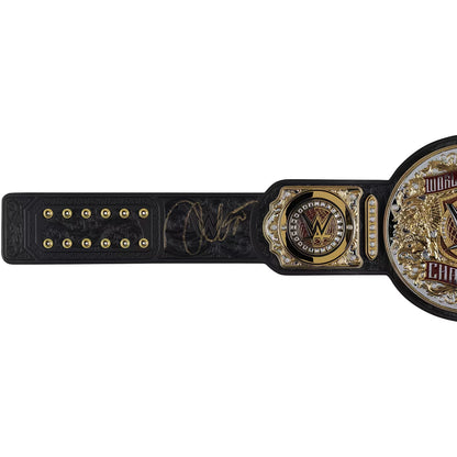 A black and gold WWE Championship belt with an engraved signature, shown horizontally against a plain white background.