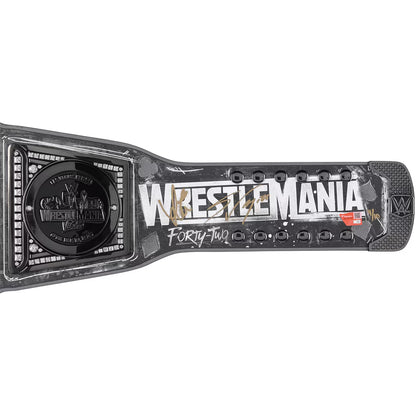 WrestleMania Forty-Two championship belt buckle and strap, featuring a black and silver design with distressed white lettering and gold and red accents, shown on a plain white background.