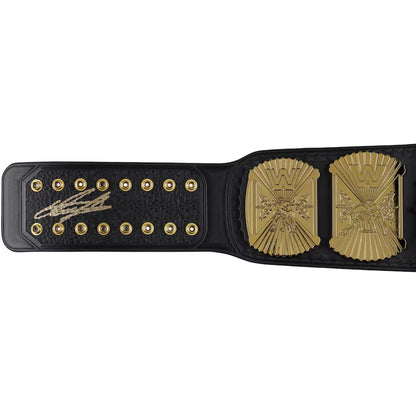 A black leather championship belt with gold-toned hardware, featuring a large ornate gold plate on the right and a gold signature plate on the left, photographed against a plain white background.