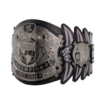 A replica or toy version of the WWE Brock Lesnar World Champion belt, featuring a large engraved silver-toned central plate and matching side plates with black and silver accents, shown on a plain white background.