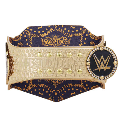 A Snoop Dogg WrestleMania championship belt featuring a navy blue and gold patterned leather strap, a gold-toned central plaque with 'WRESTLEMANIA' and studs, and a circular WWE logo medallion on the right.