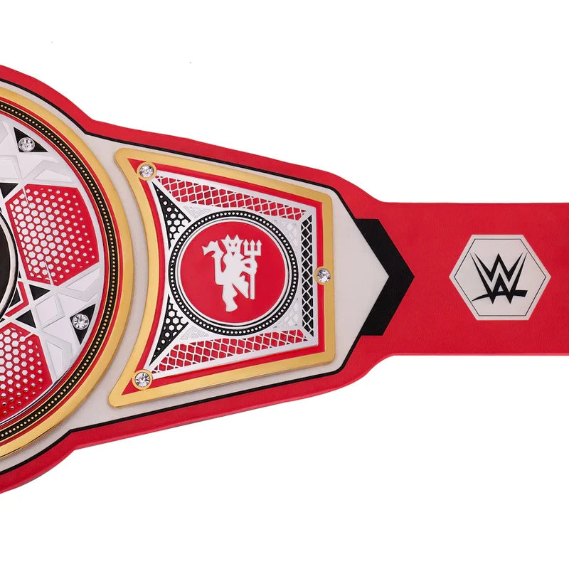A close-up of a WWE championship belt featuring a red and white design with gold trim, a central circular plate with a devil logo, and a WWE logo on the strap, set against a plain white background.