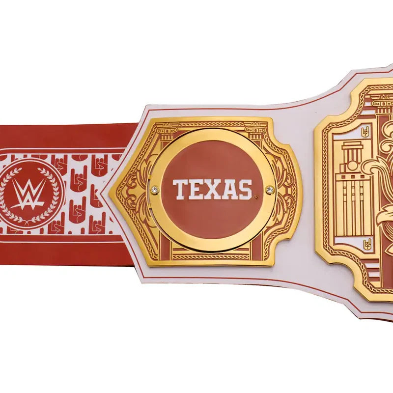 A close-up of a WWE Texas championship belt featuring a red and gold central plate with the word 'TEXAS' in white, flanked by a red strap with white WWE logos and a white side plate with gold detailing, on a white background.