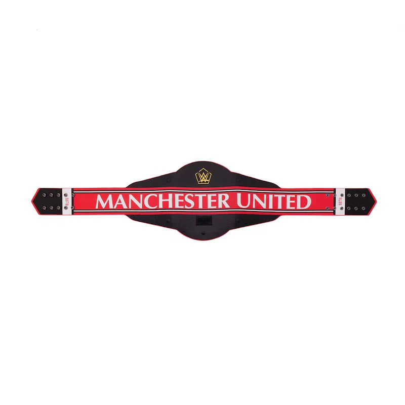 A Manchester United themed belt-shaped wall sign or plaque, featuring a black central body, a bold red horizontal band with 'MANCHESTER UNITED' in white text, and silver-toned metal end caps on a plain white background.