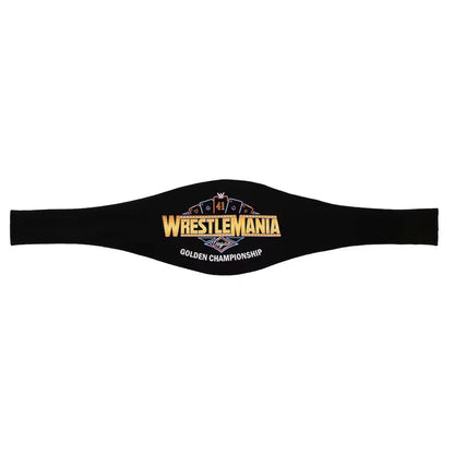A black WrestleMania Golden Championship belt laid flat against a white background, featuring gold, blue, and white embroidered details.