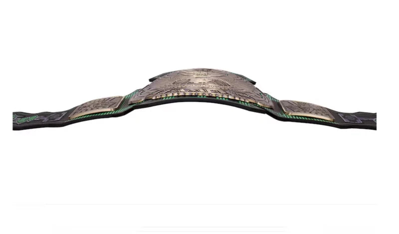 A championship belt with a large central plate featuring a textured metallic design, flanked by two smaller matching plates and black straps with green trim, shown against a plain white background.